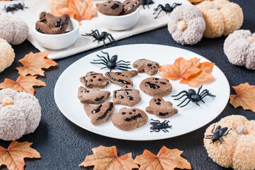 Ready-to-eat halloween treat - gingerbread cookie with chocolate icing on a plate on the table. Sweet food