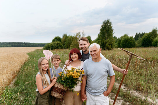 Happy family with flowers and rake at field