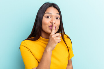 Young Venezuelan woman isolated on blue background keeping a secret or asking for silence.