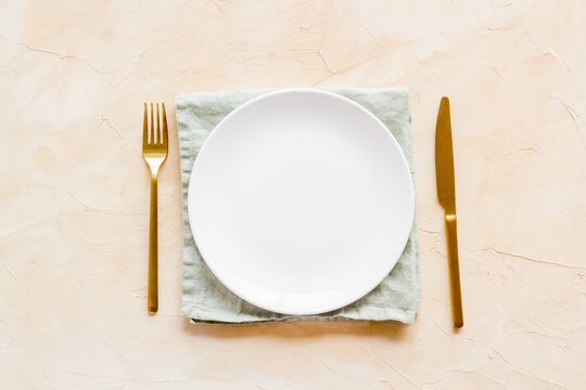 Dinner plate setting with cutlery and napkin. Top view