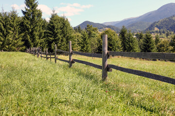Fototapeta na wymiar Beautiful view of mountain countryside with wooden fence