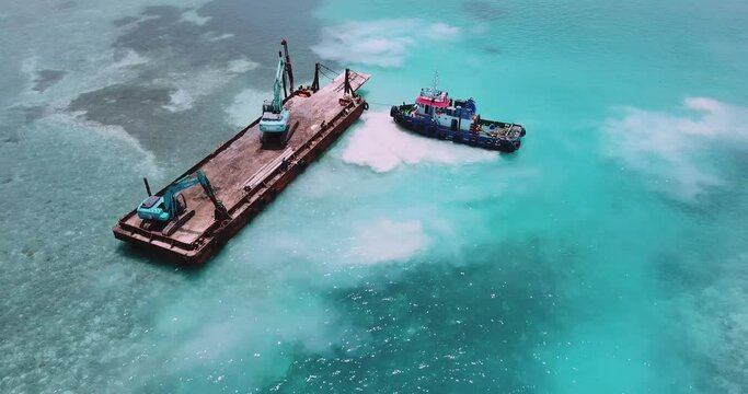 Aerial view of earth movers handling poles on floating platform. High quality 4k footage