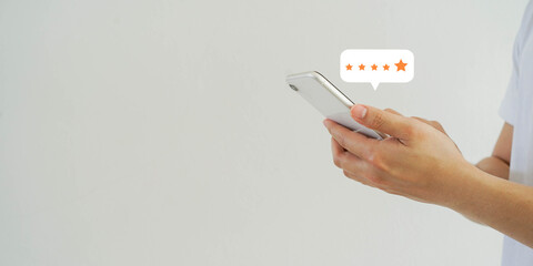 close up on businessman hand pressing on smartphone screen with gold five star rating feedback icon...