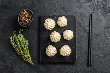 Obraz na płótnie Canvas Chinese baozi dumplings on a marble board. Black background. Top view