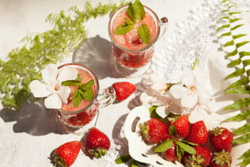 Refreshing summer drink with strawberry on light background