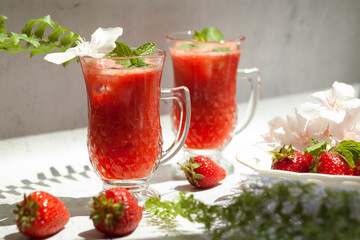 Refreshing summer drink with strawberry on light background