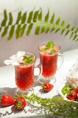 Refreshing summer drink with strawberry on light background