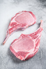 Raw dry aged tomahawk pork chop steak. White background. Top view