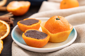 Fototapeta na wymiar Truffle chocolate tangerine candies on a black concrete background. Side view, selective focus.