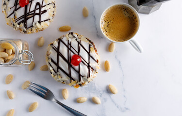 frangipane pie. Homemade frangipane cake made from almonds with sugar glassing and a cherry on top and a coffee on the side. Top view.