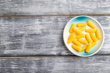 Jelly corn candies on gray wooden background. copy space, top view.