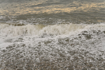 white sea foam near the shore close-up, waves