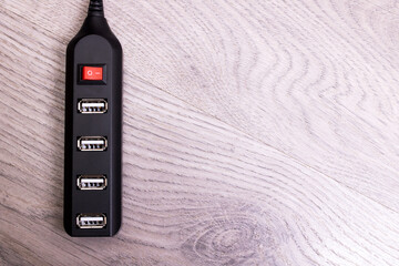Black USB hub on a wooden background