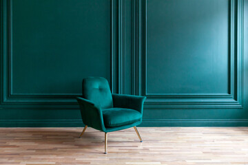 Beautiful luxury classic blue green clean interior room in classic style with green soft armchair. Vintage antique blue-green chair standing beside emerald wall. Minimalist home design.