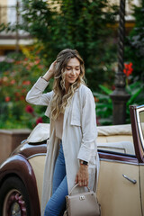 girl posing on the background of a retro car