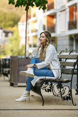 girl posing on a bench against the background of the city