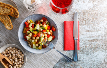Homemade chickpea salad. Homemade healthy vegan salad, with chickpea , tomato, cucumber, paprika served in a bowl. Healthy meal, on a dinner table.