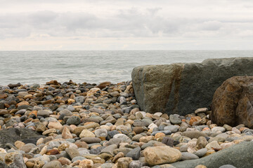 Fototapeta na wymiar View of large stones in the sea and on the beach. . High quality photo