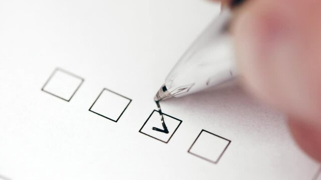 Person selecting one tickbox on a document form with black pen