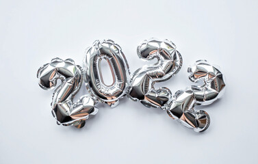 Banner. Happy New Year. Silver foil balloons with number 2022 on an isolated white background. Flat lay. 