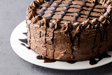Chocolate and buttercream frosted chocolate cake on grey background with space for text