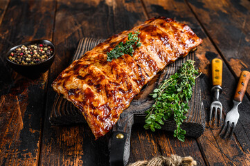 BBQ grilled pork spare ribs on a cutting board. Wooden background. Top view