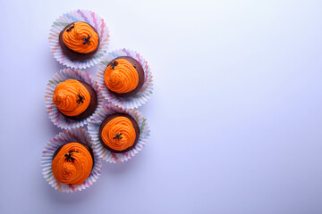 Halloween chocolate cupcakes with decor on white background with place for text. Top view