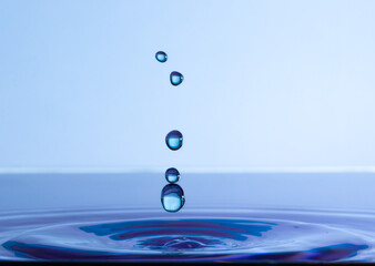 Close up of a water drop impact on a body of water and splash. environment photo of a water droplet...