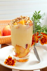 Dessert with ricotta, peach, apple and walnuts on a white plate