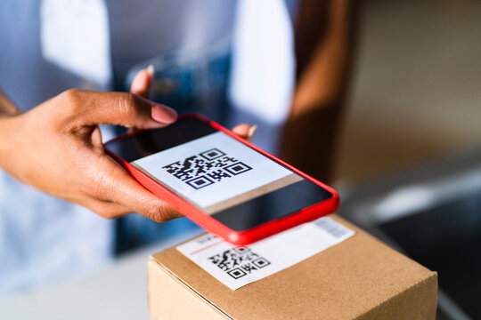 Woman scanning barcode on package at studio