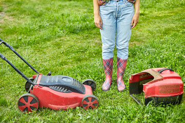 unrecognizable Woman with a lawn mower grass at home garden, gardener woman working, Beautiful summer landscape, sunlight, great design for any purposes, gardening concept