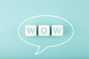 White speech bubble with wow inscription on bright tiffany blue background. Colored elegant and...