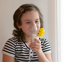 Sad girl in a mask from an inhaler nebulizer breathing treatment of the respiratory tract
