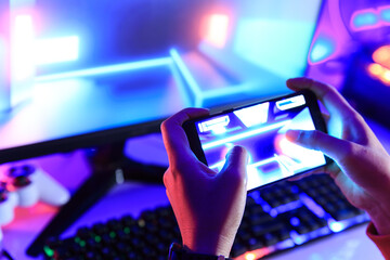 Gamer playing online game via smart phone in dark room