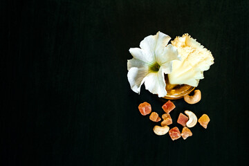 Fototapeta premium Savory pieces of cheese served with nuts, fruit and honey. Cheese of different varieties on a wooden plate. Dark background.