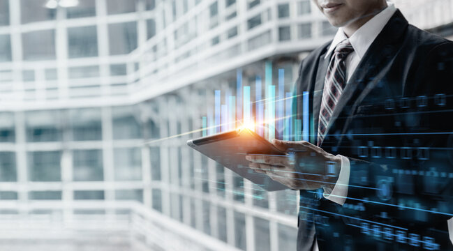 Businessman using tablet computer for analysis chart data of stock market - Powered by Adobe