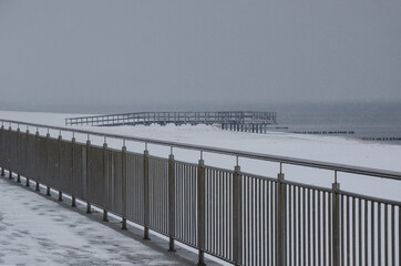 SEA COAST IN WINTER - Snowstorm on the promenade, pier and beach 
