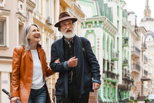 White senior couple talking and laughing while walking on street