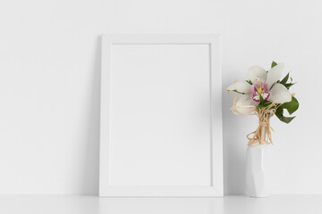 White frame mockup with a orchid on the white table.