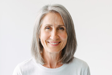 Grey senior woman in t-shirt smiling and looking at camera