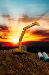 Crawler excavator is digging in the construction site pipeline work on sunset  background,With...