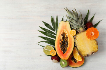 Fototapeta na wymiar Exotic fruits on white wooden background, space for text