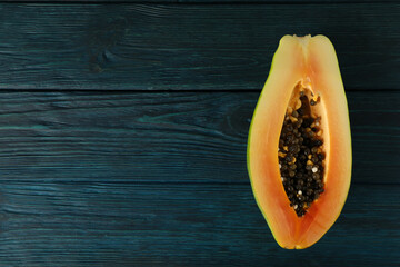 Half of papaya on dark blue wooden background