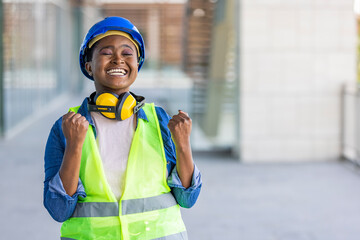 African American woman engineer wearing safety helmet, celebrating surprised and amazed for success with arms raised and open eyes. Winner concept.