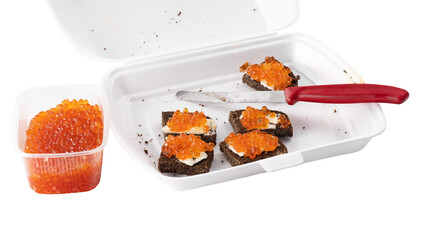 Sandwich with red salmon caviar with black bread in a plastic container with a knife. The concept...