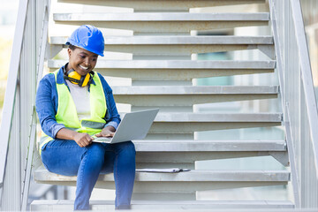 Engineer women use laptop working. Attractive young african architect using laptop. Girl foreman with laptop at construction site. Female engineer works on a computer