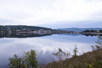 Panoramic view of a small town and its reflection in the South-Western Basin seen during a grey morning, Gaspé, Quebec, Canada
