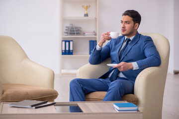 Young male employee waiting for business meeting