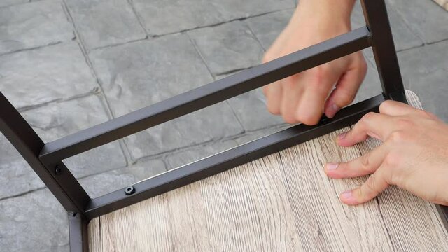 Man doing DIY assembly steel chair frame furniture interia decoration 