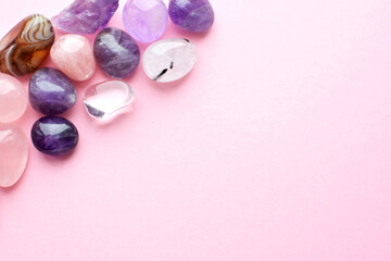 Beautiful gemstones  on a pink background. Amethysts and rose quartz. Large crystals of semi-precious stones.